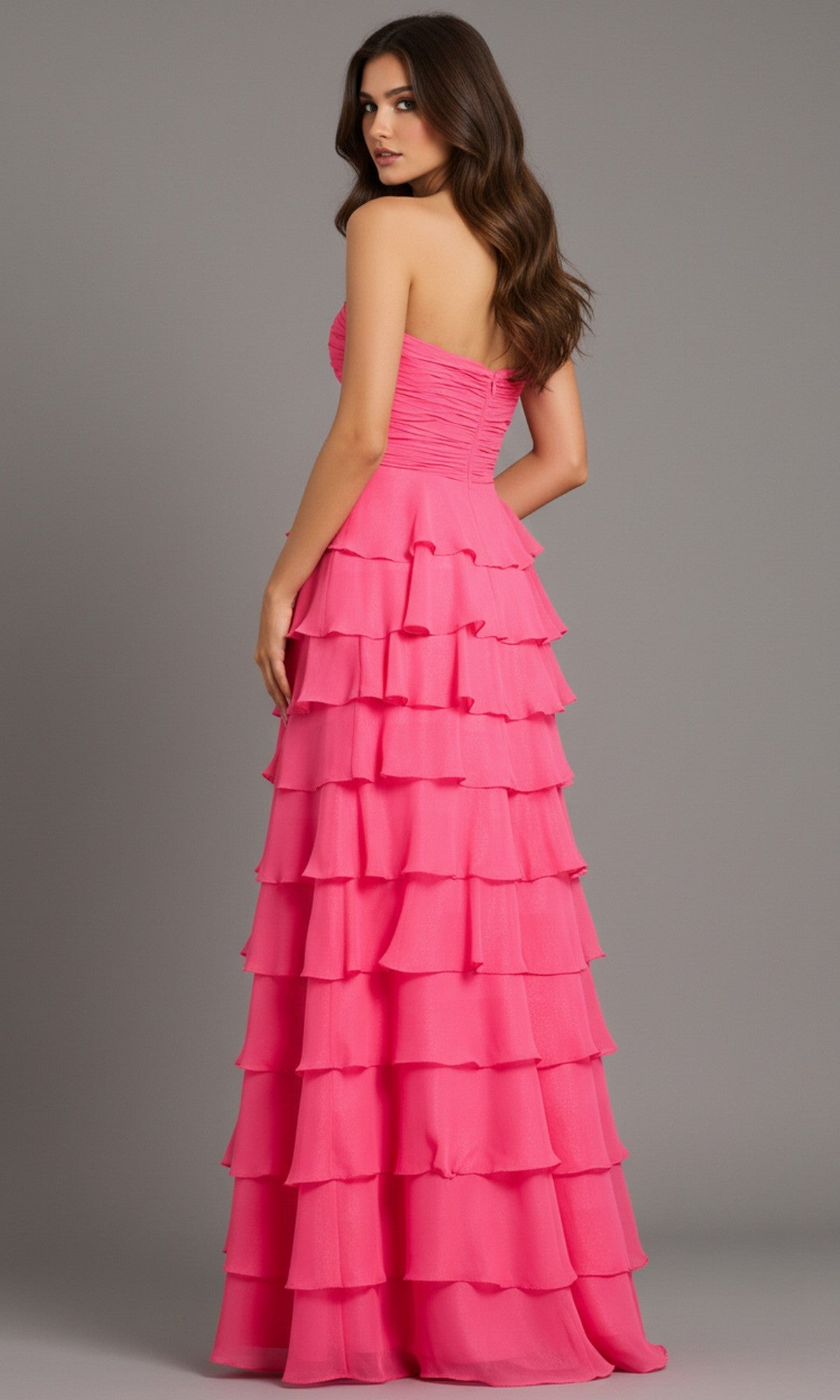 Woman models the Jovani 47898 long prom dress, featuring a strapless ruffle-tiered bodice and chiffon A-line skirt, as she stands looking over her shoulder against a plain background.